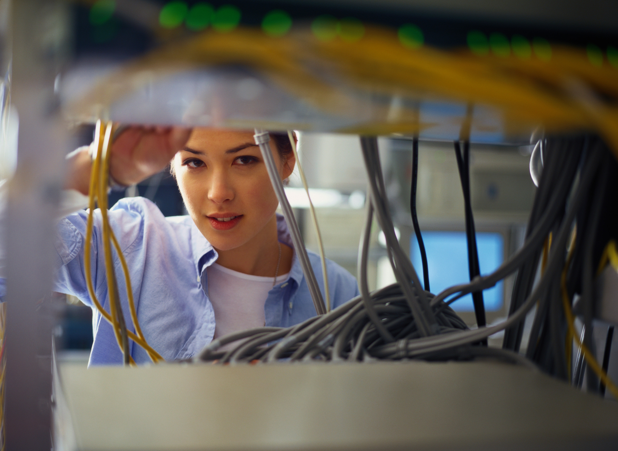 Young woman adjusting server cable